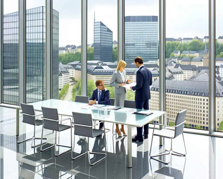 Luxembourg financial professionals discussing real estate fund strategies in a modern office
